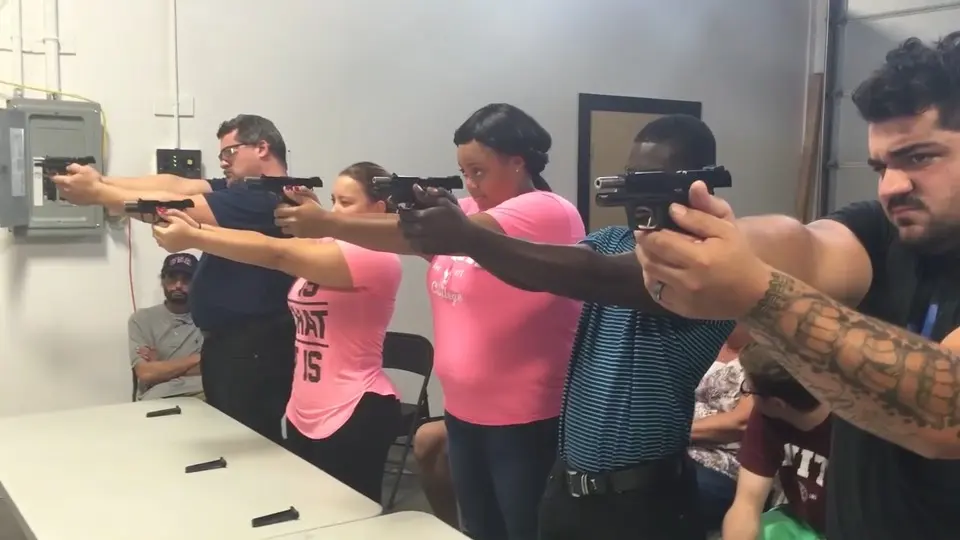 An instructor beside a student, adjusting her grip on the line.