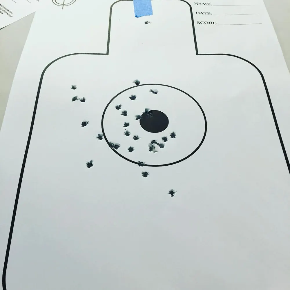 A paper target with a tight group of shots around the bullseye.